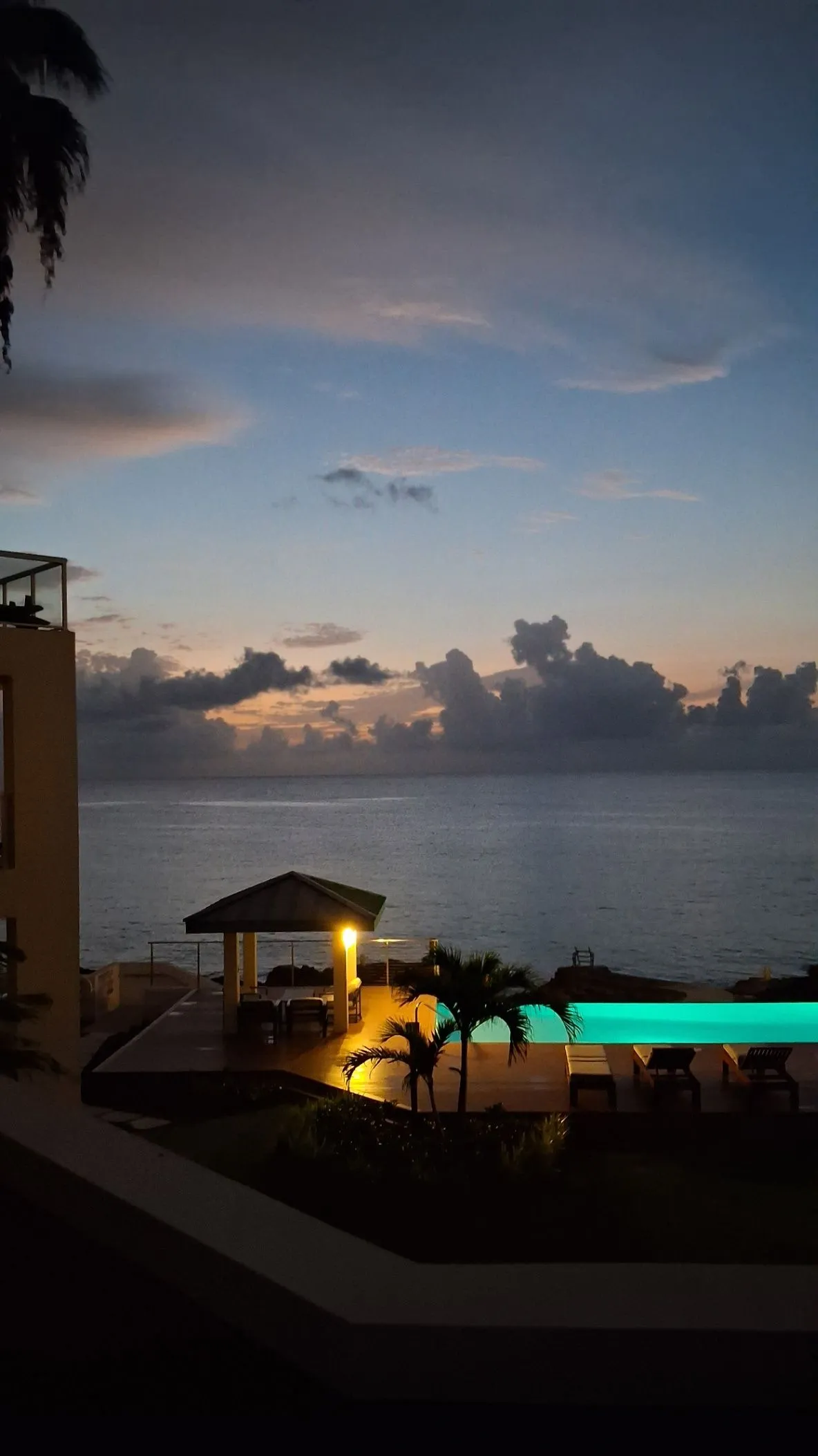 Grand Cayman sunset, illuminated gazebo, infinity pool, and palms