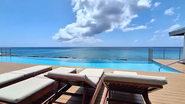 Poolside loungers overlooking the turquoise water and open sea