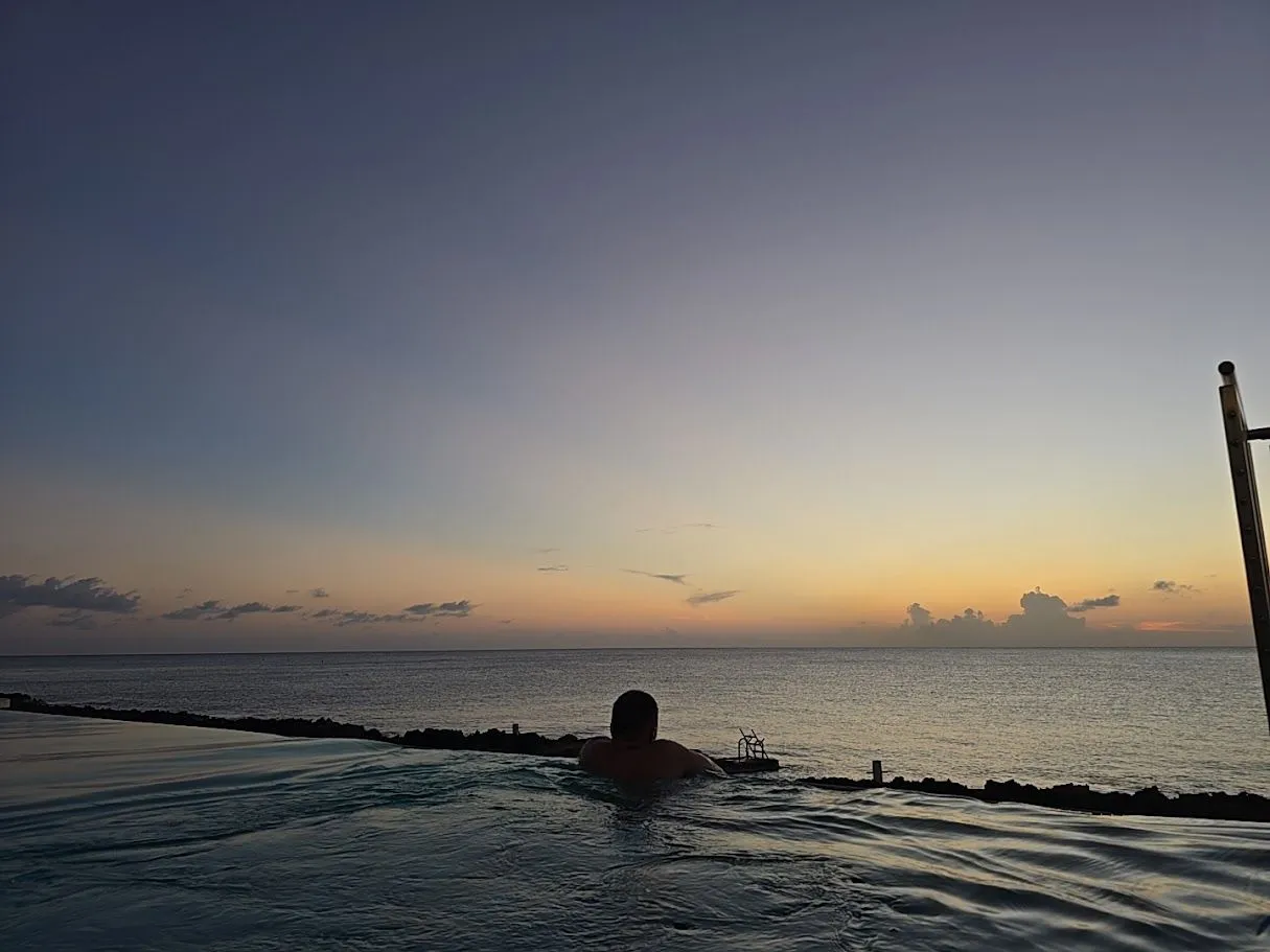 Sunset at Grand Cayman over the infinity pool and ocean